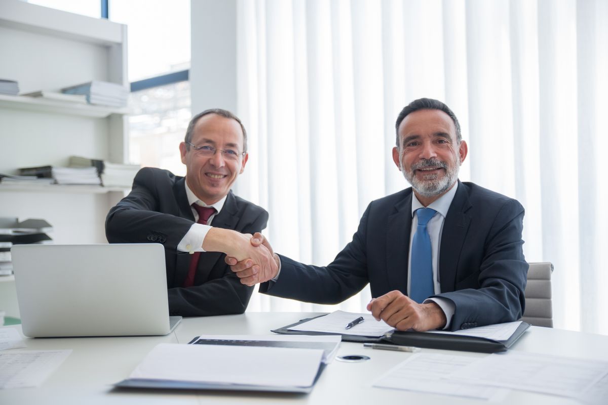 Practice owner and advisor shaking hands on a transaction agreement